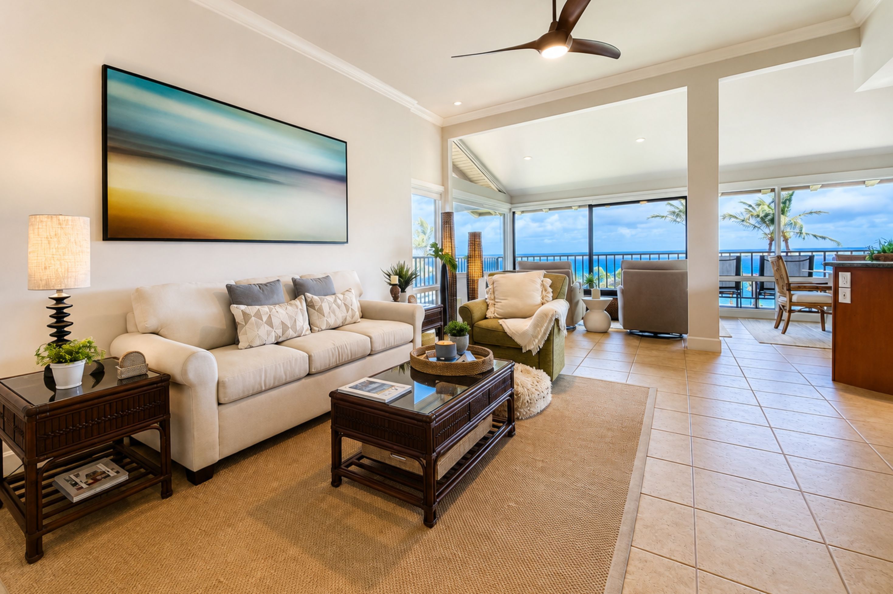A spacious living room with a large window overlooking a scenic view, a ceiling fan, and a modern fireplace.