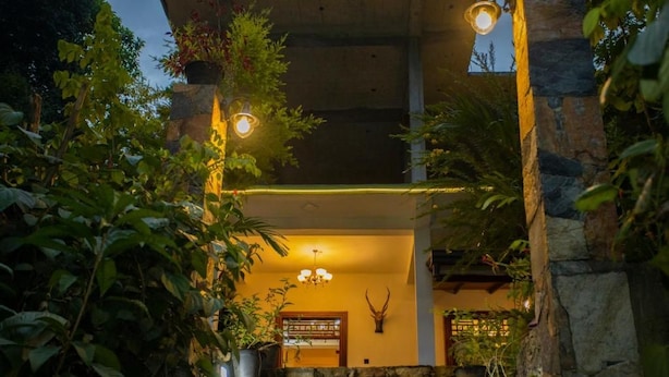 A stone-walled building with a wooden interior, a mounted animal head, and potted plants. - Asoria Luxe Villa & Retreat (Kegalle)
