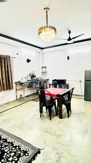 Un comedor con una mesa, sillas, una araña y un ventilador de techo.