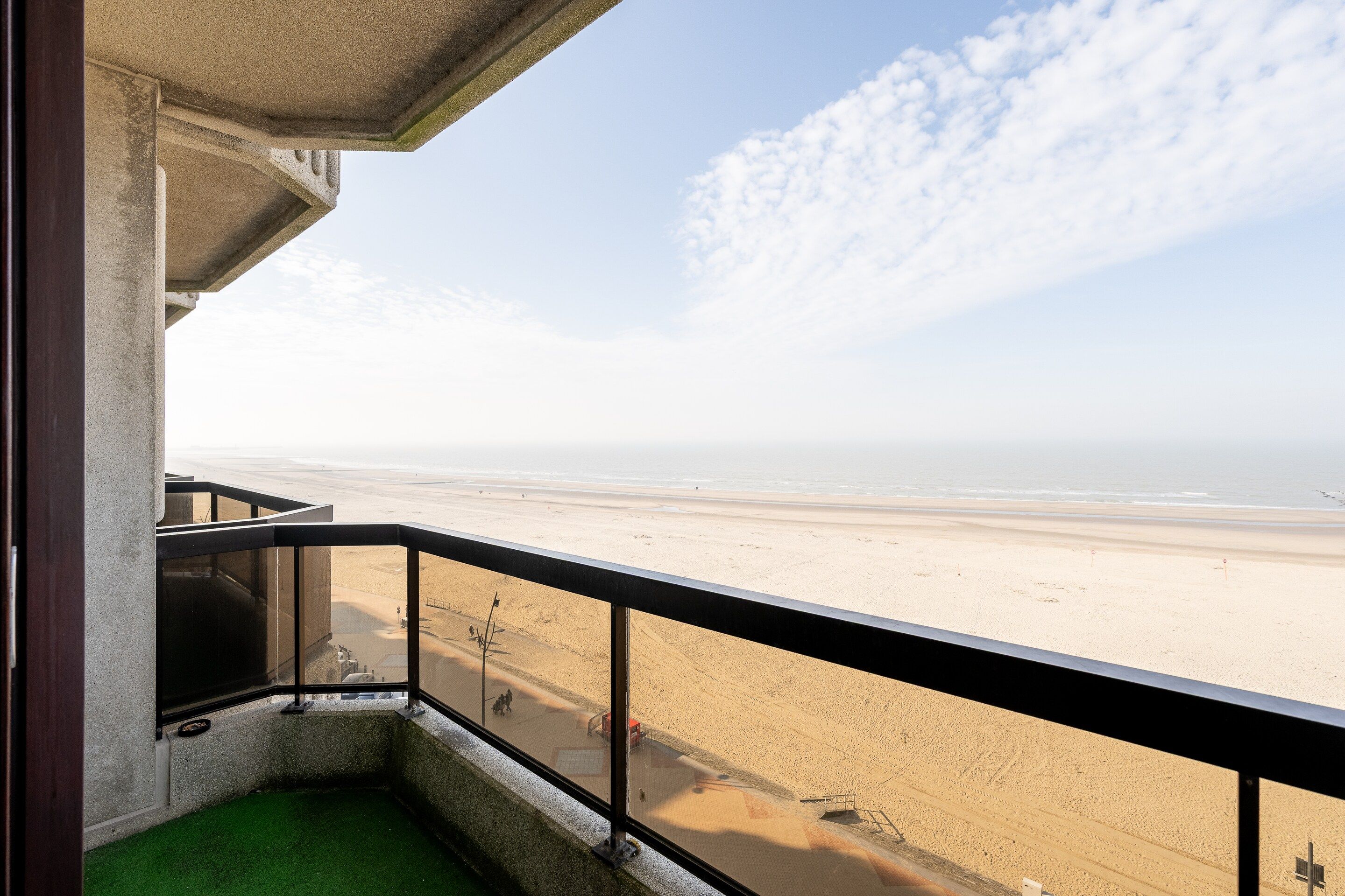 A balcony with a view of a beach and ocean.