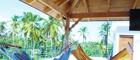 A wooden structure with a view of palm trees and a clear sky.