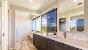 A modern bathroom with a large mirror, dark wood cabinets, and a marble countertop. - Kapalua Bay Villas | 3 Oceanfront Villas, Sleeps 16 | Car Incl. w/ 6+ Nights | ML-4709 by KBM (Lahaina)