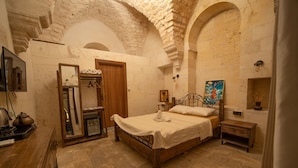 A room with a bed, a wooden wardrobe, a mirror, a small table, and a wall with a picture. - Casa Blanca otel (Şanlıurfa)