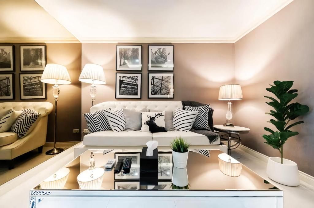 Una sala de estar moderna con un sofá, una mesa de centro y lámparas.