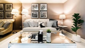 A modern living room with a sofa, coffee table, and lamps. - State Tower Bangkok (Krung Thep Maha Nakhon)