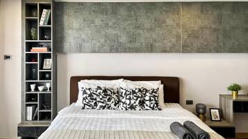 Un dormitorio moderno con cama, estantería empotrada, pared texturizada grande y mesita de noche con lámpara.