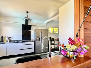 A modern kitchen with a stainless steel refrigerator, a built-in oven, and a sink. - Villa Anj'Any, 3 bedrooms, swimming pool, 300m from Grande Anse (Deshaies)