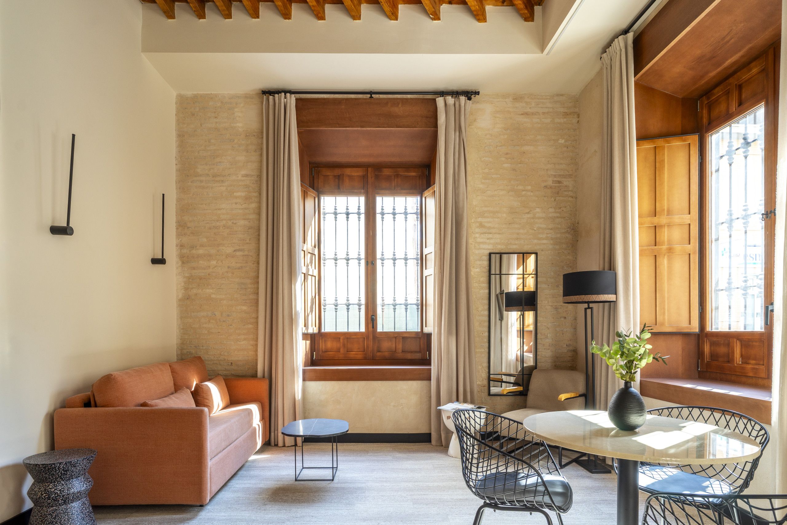 Una habitación acogedora con un sofá, una mesita redonda y una silla.