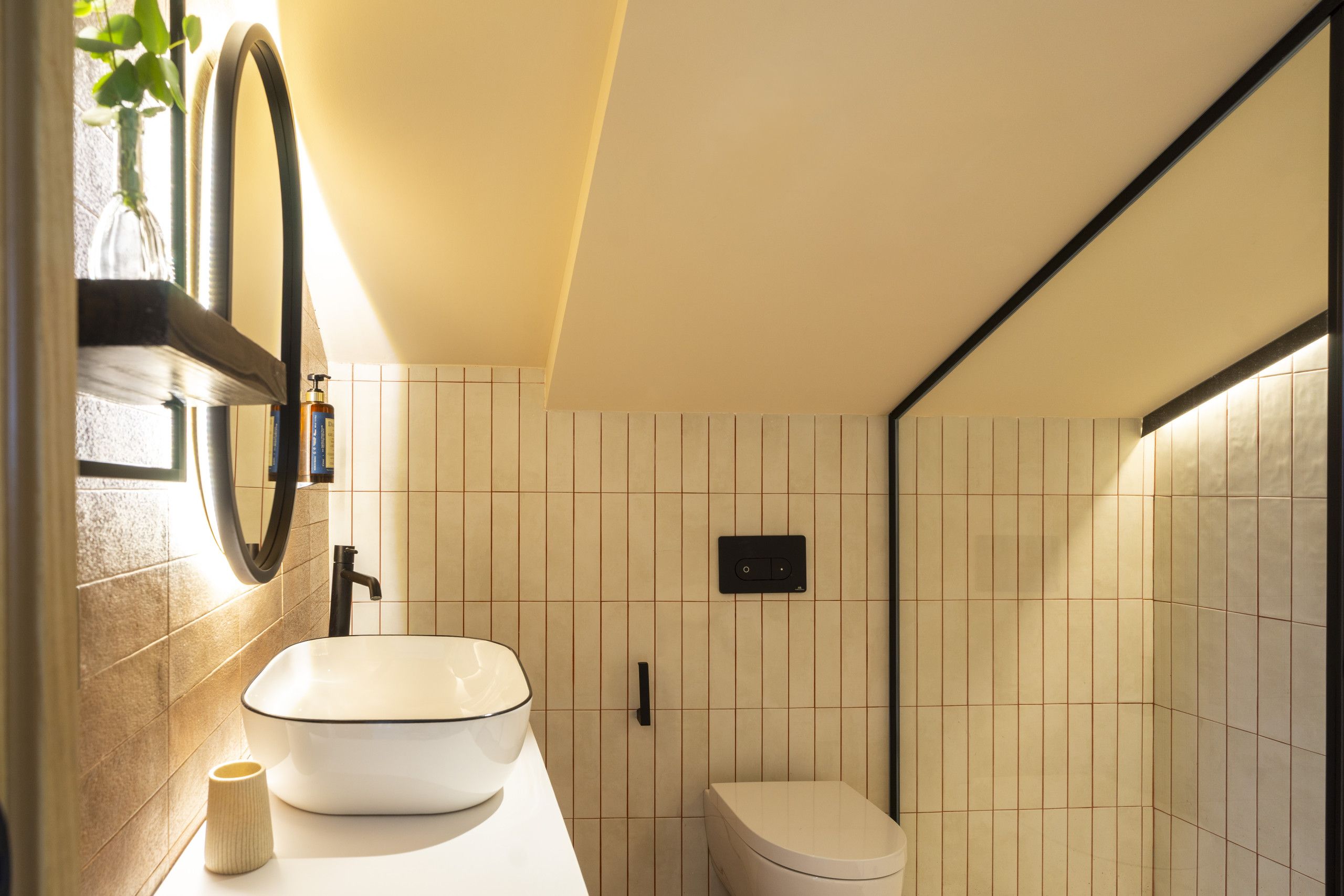 A bathroom with a white sink, a toilet, and a mirror.