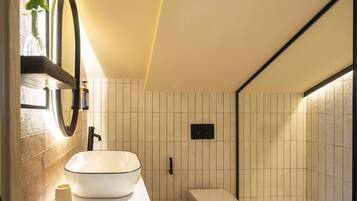 A bathroom with a white sink, a toilet, and a mirror.