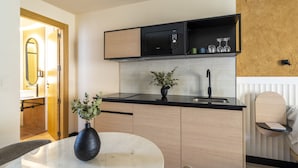 Uma cozinha moderna com micro-ondas preto, pia e área de jantar com mesa redonda e um vaso.