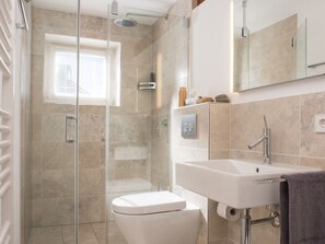 A modern bathroom with a glass-enclosed shower, a toilet, a sink, and a mirror. - Holiday Home With 4 Bedrooms (St. Peter-Ording)