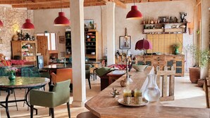 Ein rustikales Interieur mit einem Holzespeisetisch, Stühlen und Pendelleuchten.