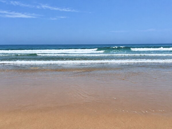 A beach with waves approaching the shore.