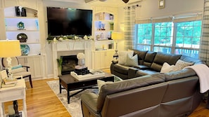 A living room with a fireplace, a television, a sofa, and a coffee table. - Dream mansion located 20 minutes away from DTWN (Kennesaw)