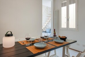 A dining area with a table set for two, a bottle of wine, and a bowl of bread. - 20 mins from Duomo • Outside ZTL • Easy Parking (FIRENZE)