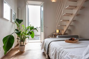 A bedroom with a bed, a potted plant, a nightstand, a lamp, and a staircase. - 20 mins from Duomo • Outside ZTL • Easy Parking (FIRENZE)