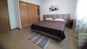 A bedroom with a bed, a wardrobe, a bedside table, and a rug. - Elegant High-End Apartment (Tunis Governorate)