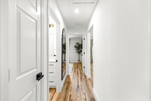 A hallway with white doors, wooden flooring, and a potted plant. - NEW 3 bedroom-6 miles to WEC-CLEAN-Pet friendly (Ocala)