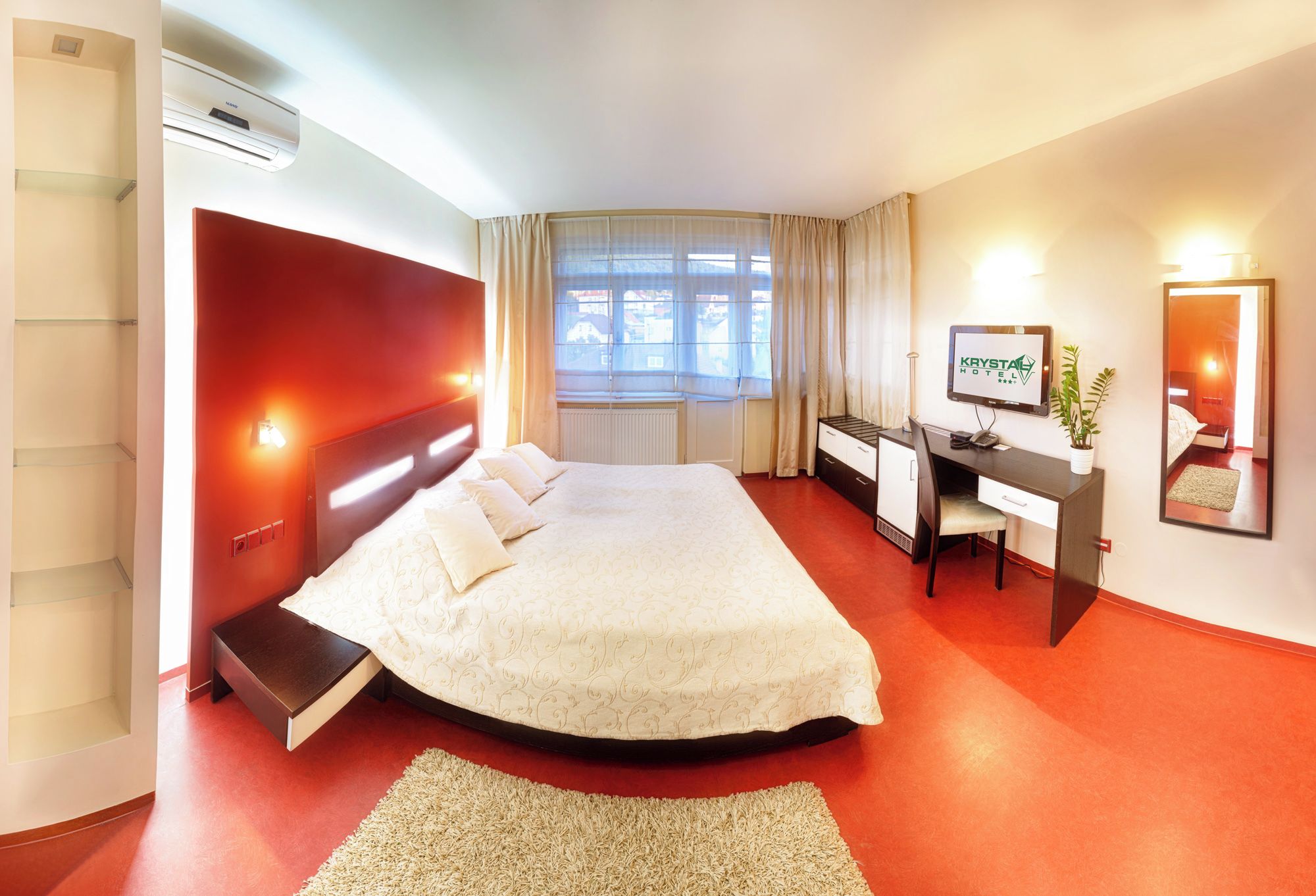 Une chambre d’hôtel équipée d’un lit, d’un bureau, d’une chaise et d’un téléviseur.