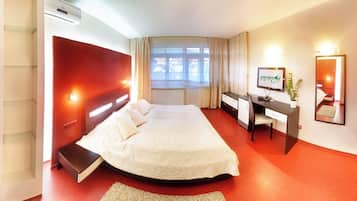 Une chambre d’hôtel équipée d’un lit, d’un bureau, d’une chaise et d’un téléviseur.
