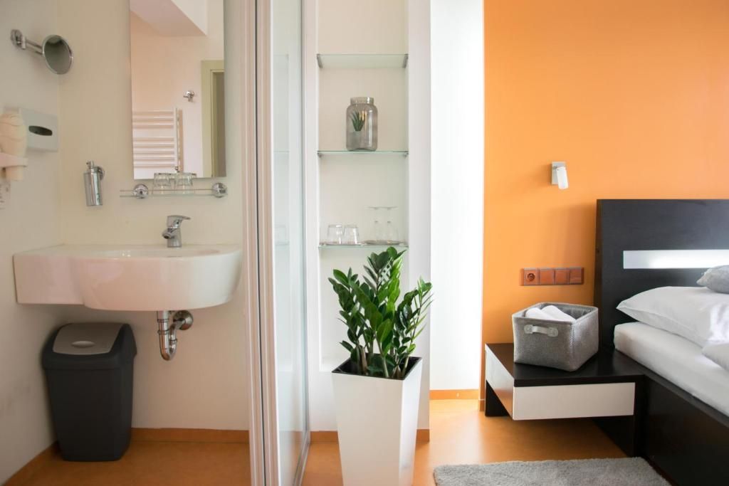A modern bathroom with a sink, mirror, and glass shelves.