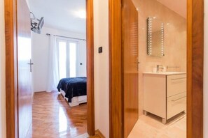 A bedroom with a bed, a bedside table, and a mirror with lights. - Apartment The Big Chill - Three Bedroom Apartment With Terrace, Balcony and Jacuzzi (Dubrovnik)
