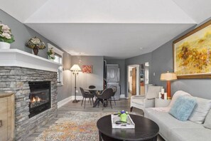 A living room with a fireplace, a dining area, and a sofa. - Charming 2BR Kisilano Duplex | Near Jericho Beach (Vancouver)