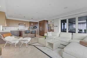Ein modernes Wohnzimmer mit einer Couch, einem Couchtisch und einer Liege.