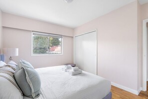 A bedroom with a bed, a window, a door, and a view of the outside. - Mid Century Modern Retreat | w/ Indoor Pool (Vancouver)