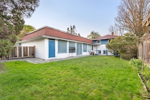 A single-story house with a red roof, a front porch, and a well-maintained lawn. - Mid Century Modern Retreat | w/ Indoor Pool (Vancouver)