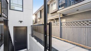 A residential building with a gated entrance, a door, and a balcony.