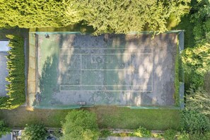 An aerial view of a tennis court surrounded by dense trees. - Grand 4BR Point Grey Manor - Walk to Beaches (Vancouver)