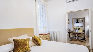 Ein Hotelzimmer mit einem Bett, einem Nachttisch, einer Heizung und Blick in den Speisesaal.