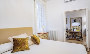 Ein Hotelzimmer mit einem Bett, einem Nachttisch, einer Heizung und Blick in den Speisesaal.