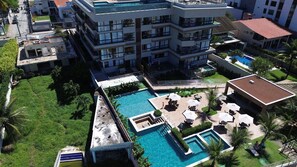 A multi-story hotel with a rooftop pool area, including a smaller pool and sun loungers. - Mirante de Porto Piscinas Naturais (Ipojuca)