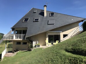 Una casa amb teulada inclinada, un balcó i una escala que condueix a l'entrada.