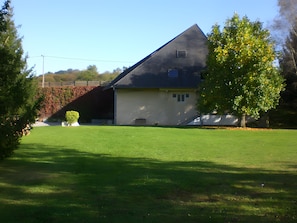 Une maison de plain-pied avec un toit en pente, un petit porche à l’avant et une pelouse bien entretenue.