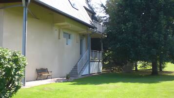 A building with a porch, a staircase, and a bench.