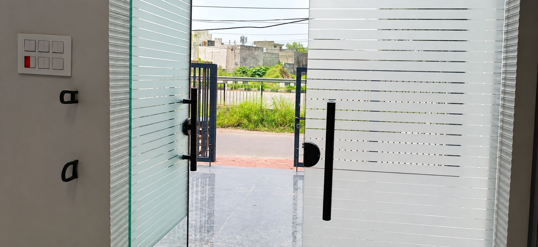 A glass door with a handle, a keycard reader, and a keypad lock.