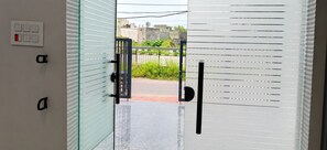 Una puerta de vidrio con picaporte, lector de tarjetas de acceso y teclado electrónico.