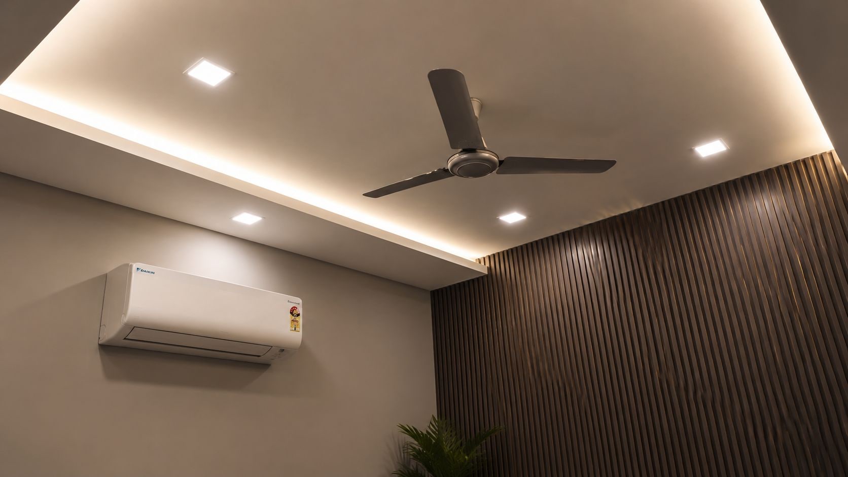 A ceiling fan, recessed lighting, and an air conditioning unit in a room with a wooden panel wall.