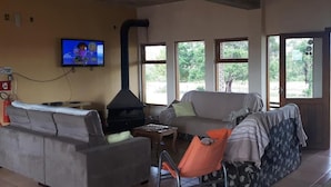 Olohuone, jossa on sohva, nojatuoli, televisio ja takka.