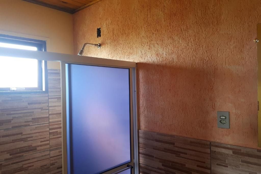A room with a large window, a door, and a textured wall.