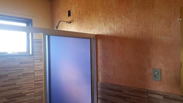 Una habitación con un ventanal grande, una puerta y una pared con textura.