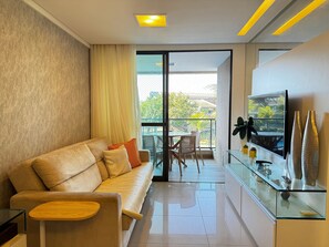 Ein modernes Wohnzimmer mit einer Couch, einem Glastisch und einem Fernseher in einem Glasschrank.