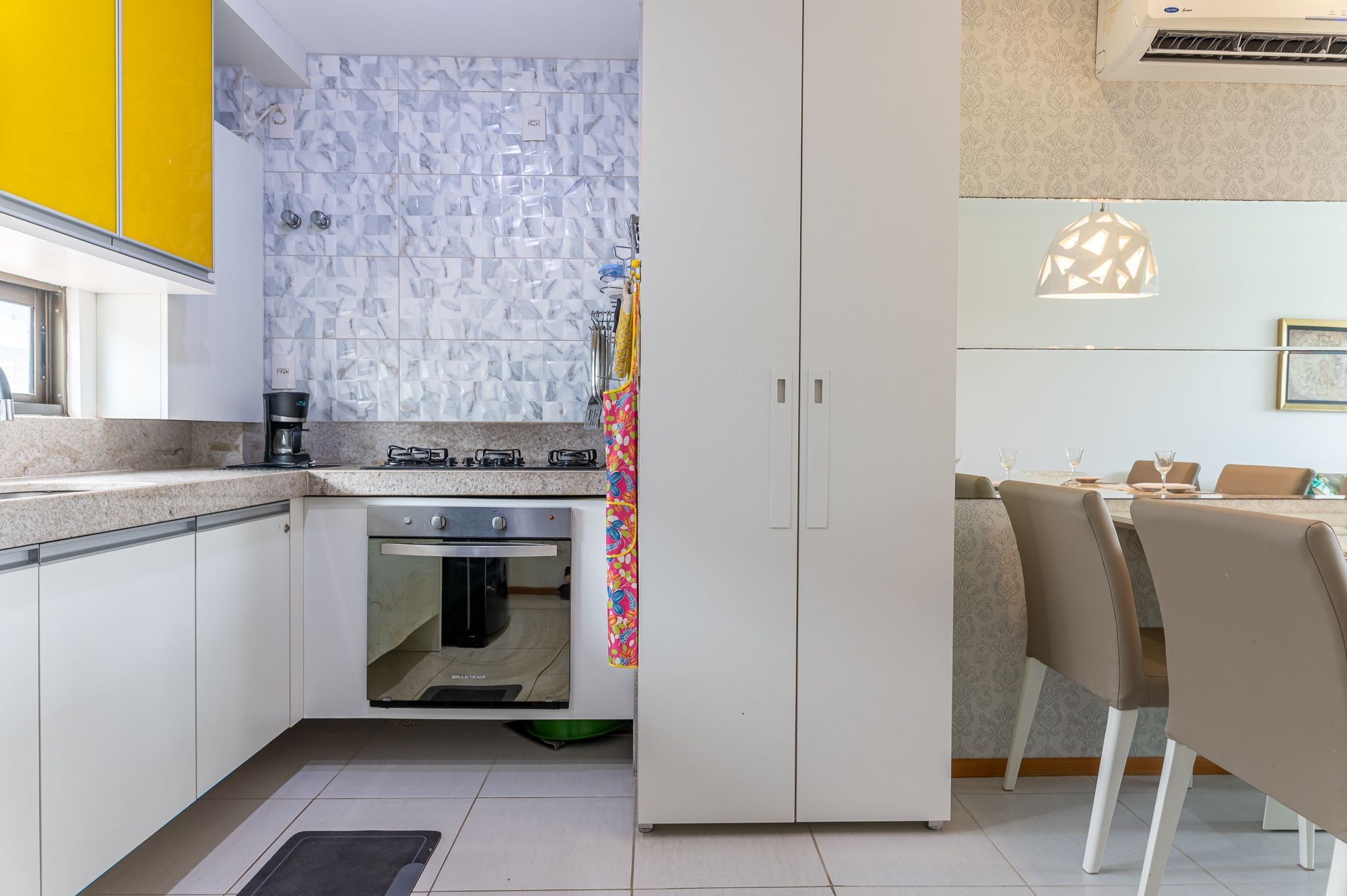 A modern kitchen with a gas stove, oven, and white cabinets.