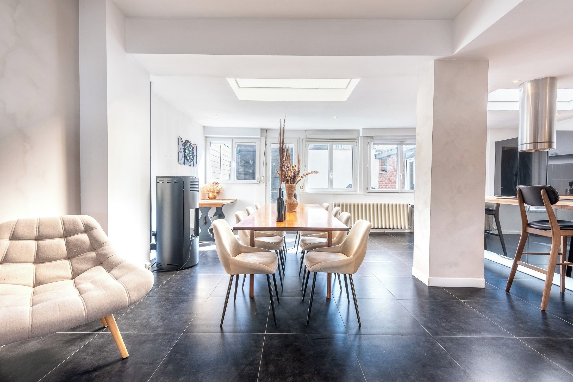 A modern living room with a dining area, a sofa, a coffee table, and a fireplace.