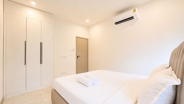 Ein Hotelzimmer mit einem Bett, einem Kleiderschrank, einer Tür und einer Klimaanlage.