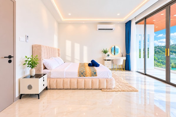 A modern bedroom with a bed, bedside table, and a view of a balcony.